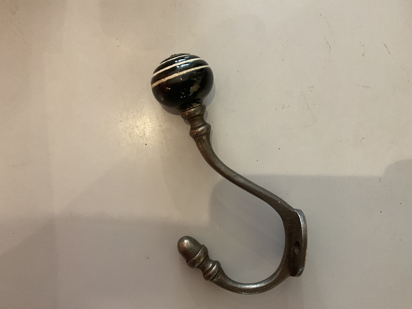135 - Antique Iron Hat and Coat Hook, Black/white Striped Ceramic Tip